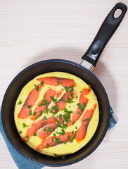 omelet with smoked salmon in a frying pan