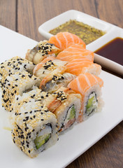 Sushi set on a white plate over vintage wooden background