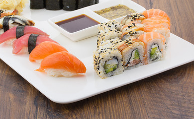 Sushi set on a white plate over vintage wooden background
