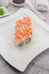 Japanese cuisine. Sushi on a white plate over vintage wooden background.