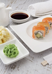 Japanese cuisine. Sushi on a white plate over vintage wooden background.