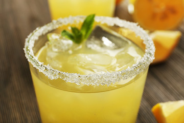 Glasses of lemon juice on wooden table, closeup