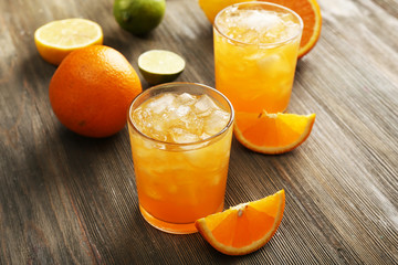 Glasses of orange juice on wooden table, closeup
