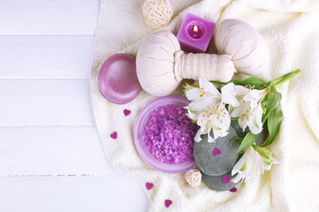 Obraz na płótnie Canvas Massage bags with spa treatment and flowers on wooden table background