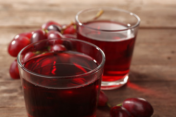 Glass of grape juice on wooden table, closeup