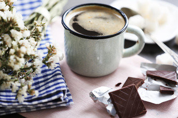 Cup of flavored coffee with chocolate on table with napkin, closeup