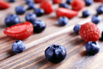 Tasty ripe berries on wooden table close up