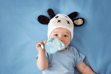 Baby in a cow hat drinking milk