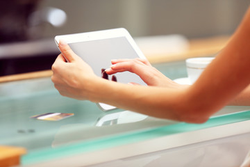 Woman hands using tablet on table close up