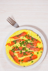 omelet with smoked salmon in a frying pan