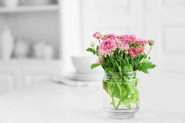 Fototapeta na wymiar Beautiful flowers in vase on table, on light background