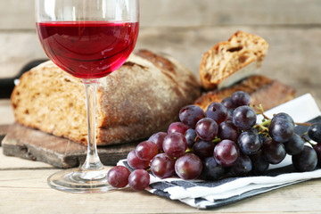 Still life of wine and bread on rustic wooden background