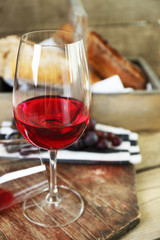 Still life of wine and bread on rustic wooden background
