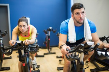 Fototapeta na wymiar Focused couple using exercise bikes