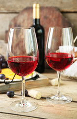 Still life of wine, grape, cheese and bread on rustic wooden background