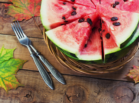 Cut in half watermelon on old wooden table. Red ripe fruit wood background  top view image