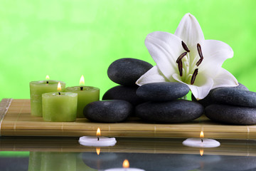 Still life with spa stones on green background