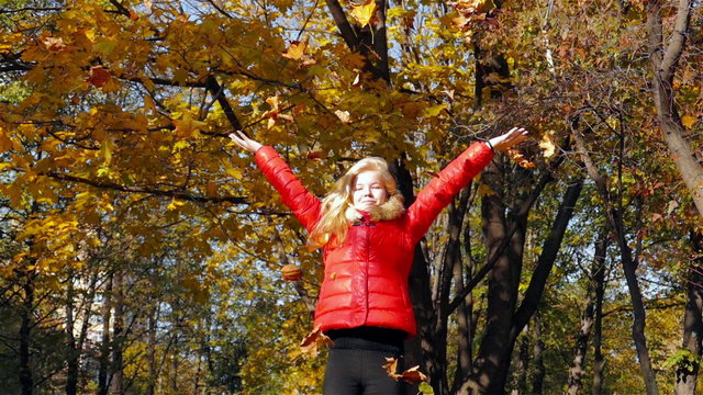Girl throwing leaves in Autumn in slow motion