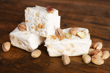 Fototapeta na wymiar Sweet nougat with pistachios on wooden background