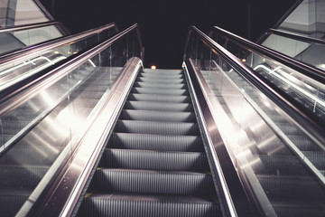 Escalator in subway station at night. Low angle view.