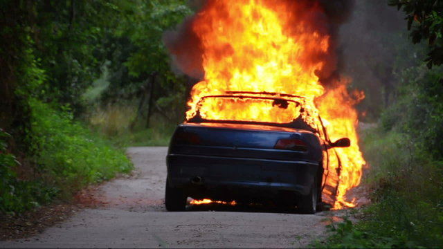 Burning Car, fire fighters extinguish the fire.