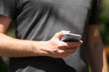 Man holding smart mobile phone outdoors