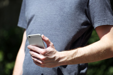 Man holding smart mobile phone outdoors