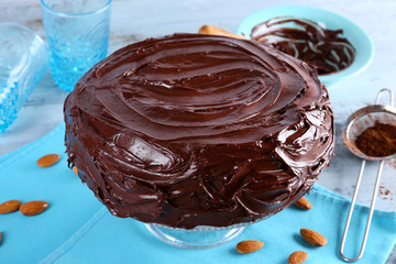 tasty cake under chocolate glaze on light blue background
