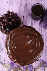 tasty chocolate pie with sweet grape and glass of tea on wooden background