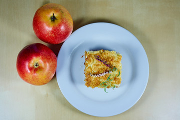 Ripe apples and apple pie on the plate.