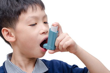 Asian boy using inhaler for asthma over white