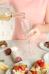 Woman pouring wine into glass, close up