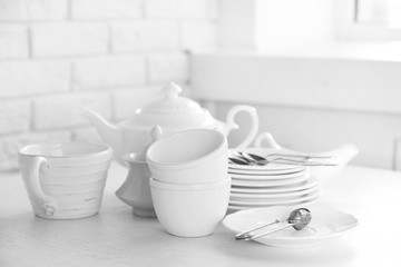Clean dishes on table on brick wall background