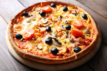 Pizza on cutting board on wooden background