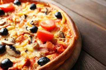 Pizza on cutting board on wooden background