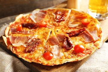 Pizza served with beer on wooden table