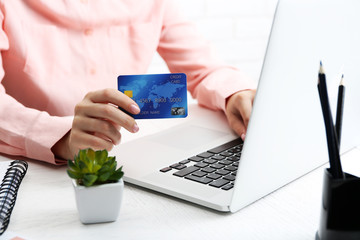 Concept for Internet shopping: hands with laptop and credit card