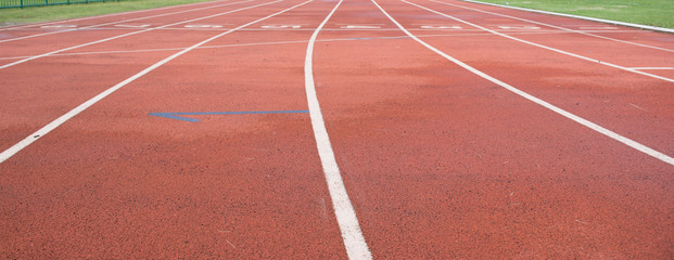White and yellow lines and arrow. Textured red rubber of running