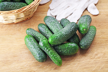 Ripe cucumbers in wicker vase on table
