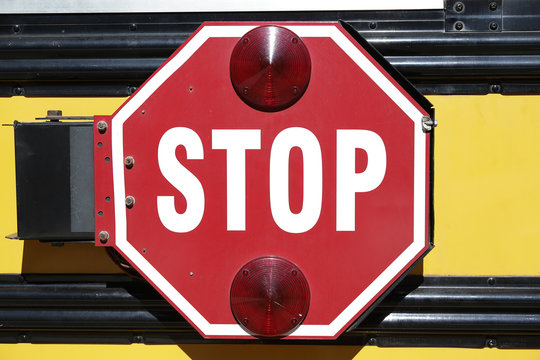 Stop sign on the side of a typical yellow school bus