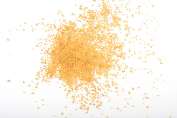 uncooked couscous scattered on white background