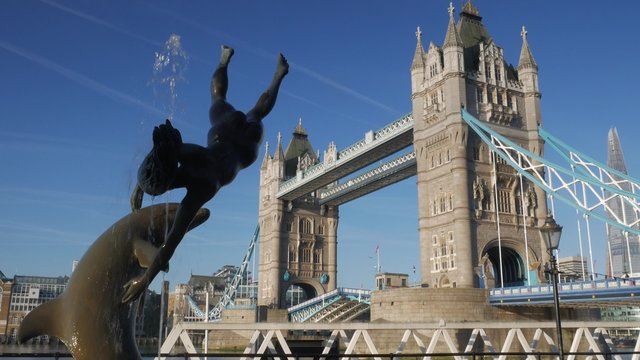 Real Time video of Tower Bridge opening, framed by the statue of girl and dolphin. Shot on a sunny autumn morning in 4K