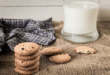 Cookies and a glass of milk on a wooden background
