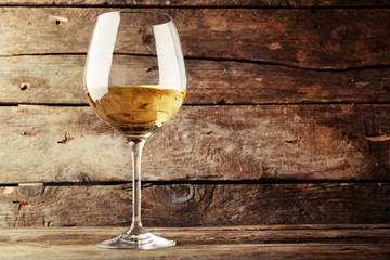 Glass of white wine on wooden table