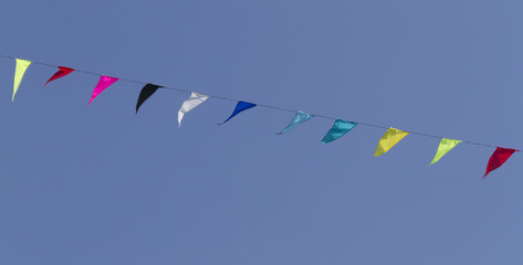 colorful kites flying  in single file in the sky