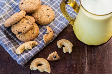 Close up cookies and glass of milk on wooden table