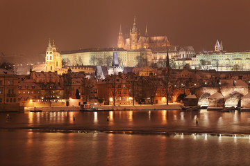 Obraz na płótnie Canvas Night romantic colorful snowy Prague gothic Castle with Charles Bridge, Czech Republic