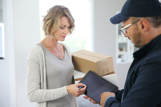 Woman receiving package from delivery man