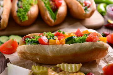 Hot dogs and vegetables on wooden cutting board