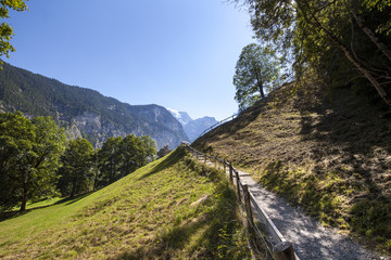 Landscape with a small mountain path and handrail around it. The meandering pathway leads up the mountain.